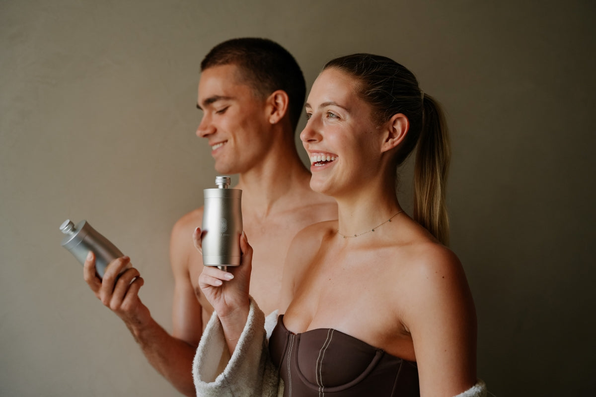 A male and female laughing and holding a shower filter