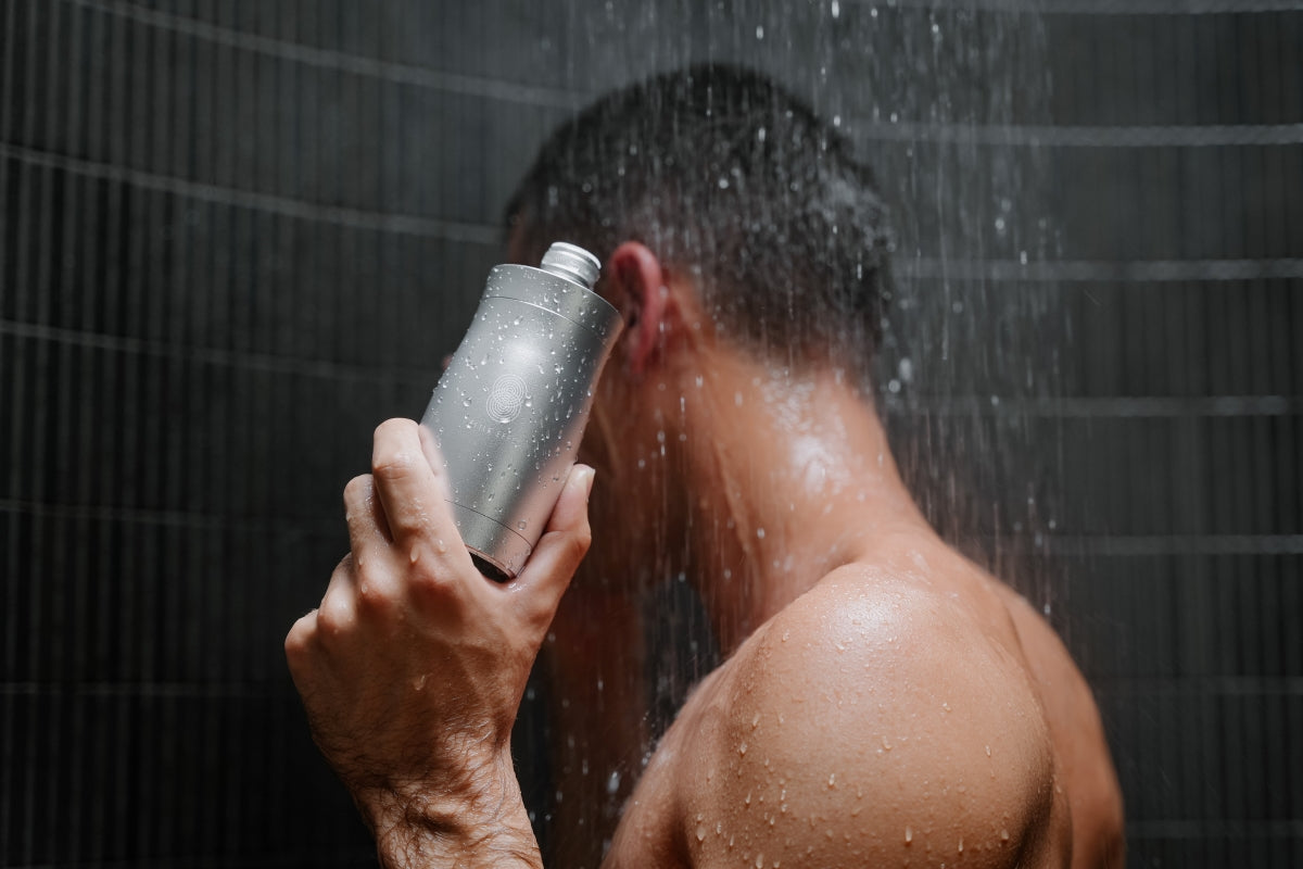 A man holding a shower filter for hard water