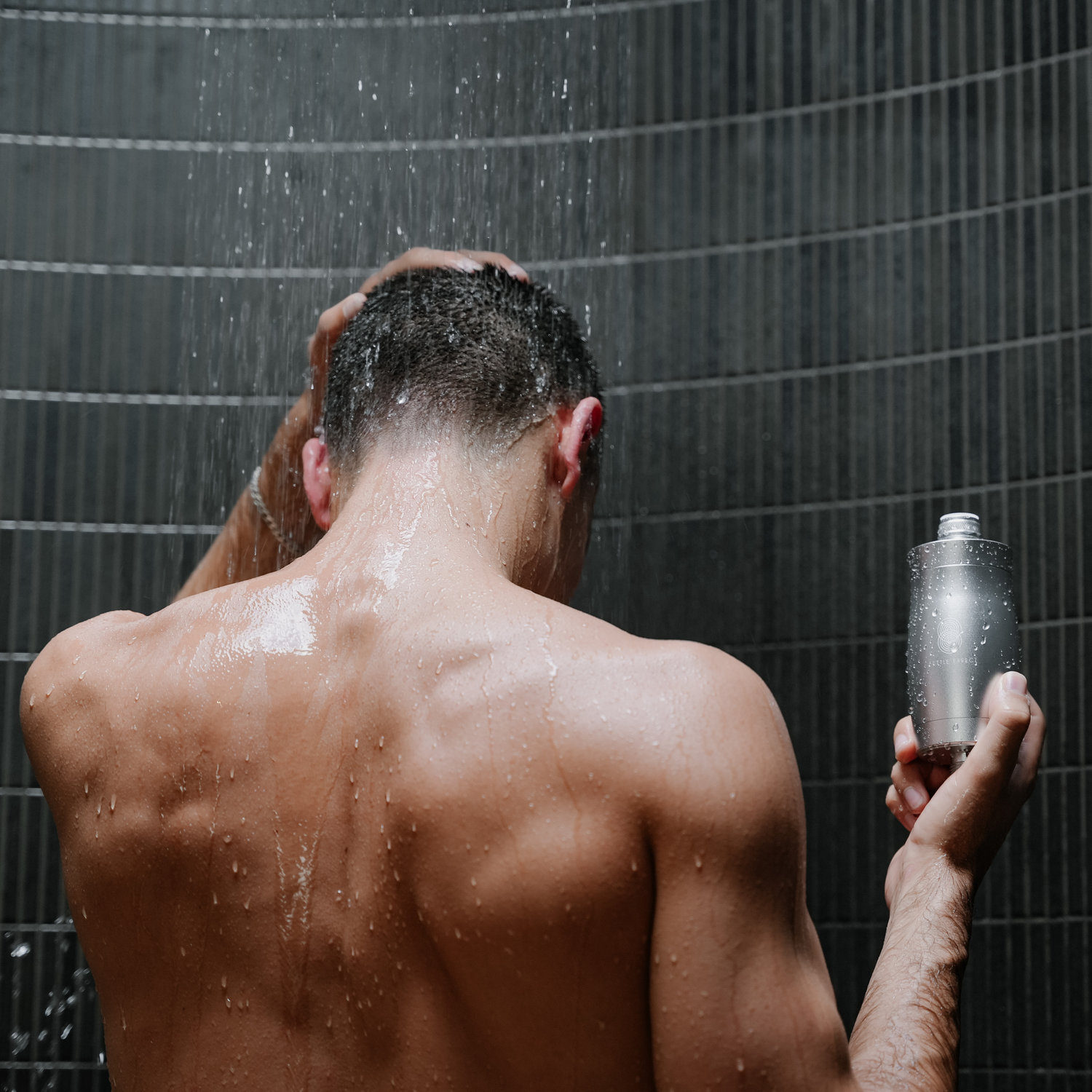 A man showering with a Fettle Effect Shower Filter